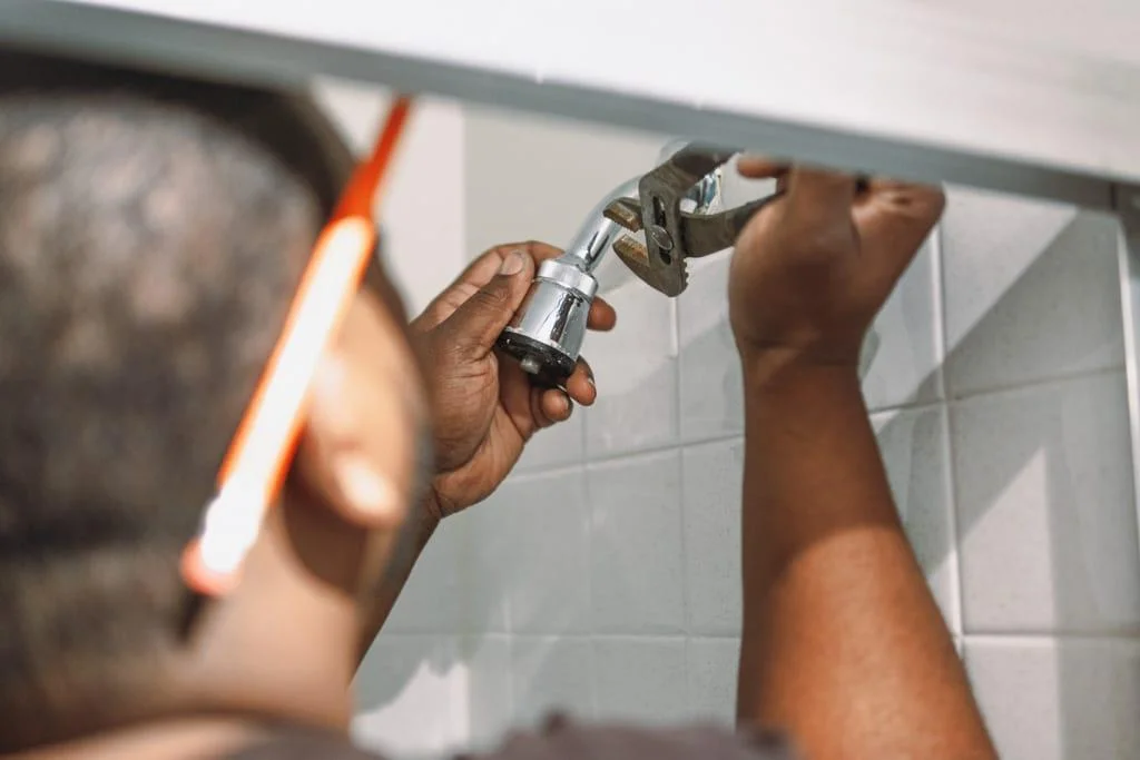 handyman plumber repairing faucet